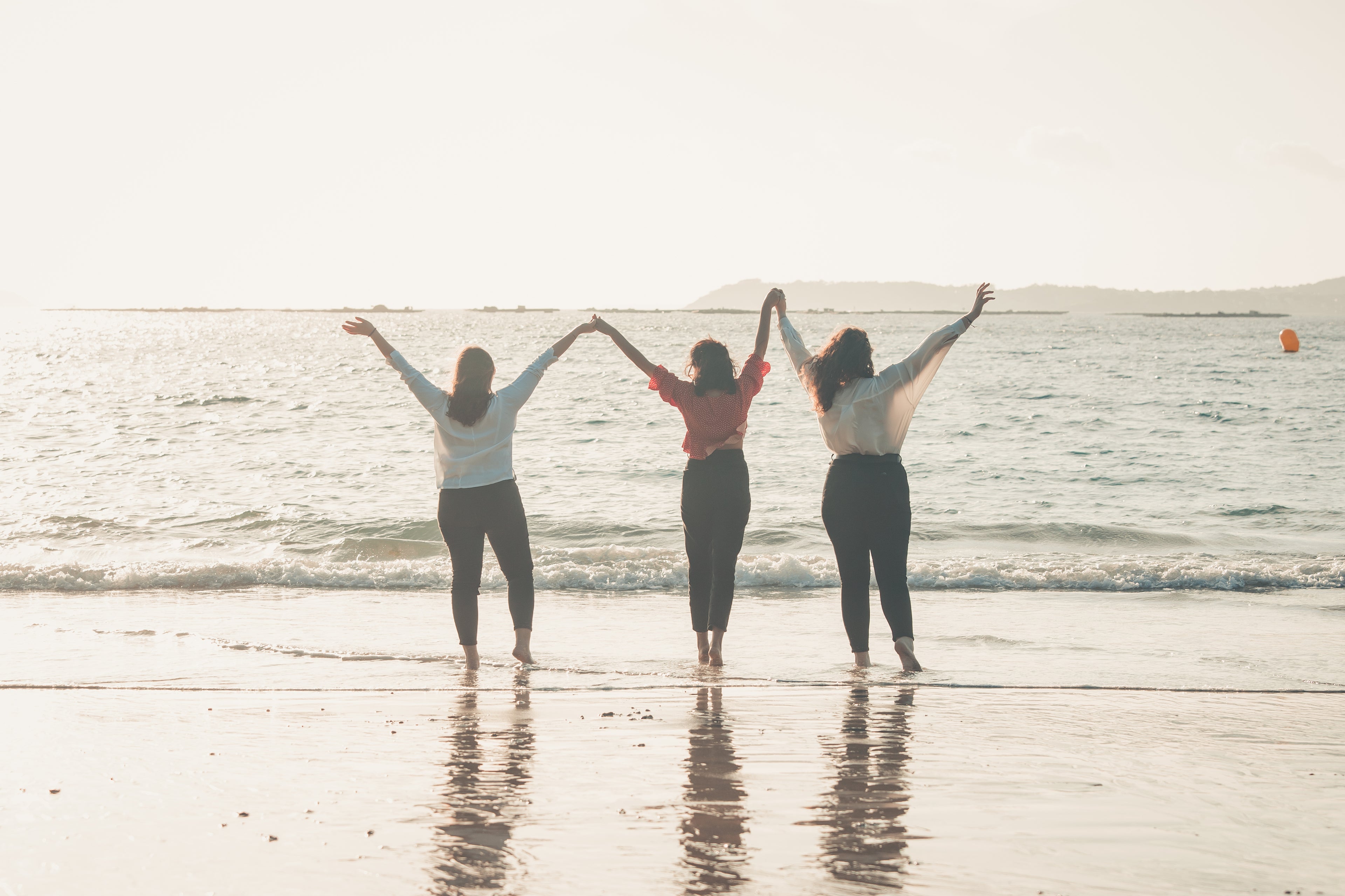 three people celebrating at the beach